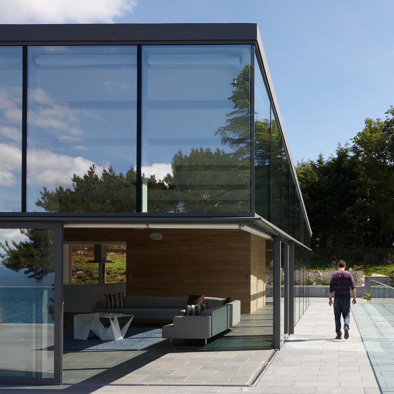 Grey aluminium patio doors that meet in the middle to create a glass wall that can be completely opened
