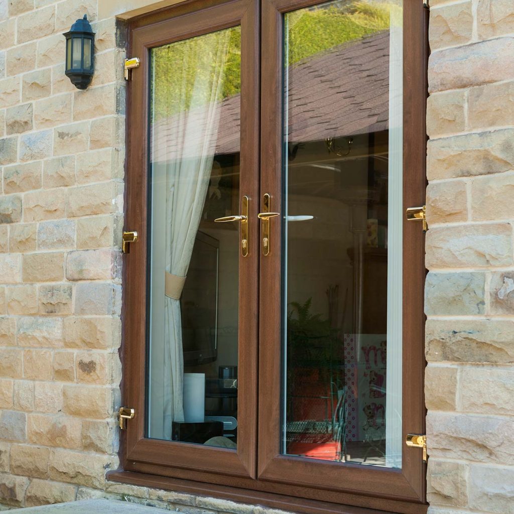 Oak finish uPVC french doors with gold furniture