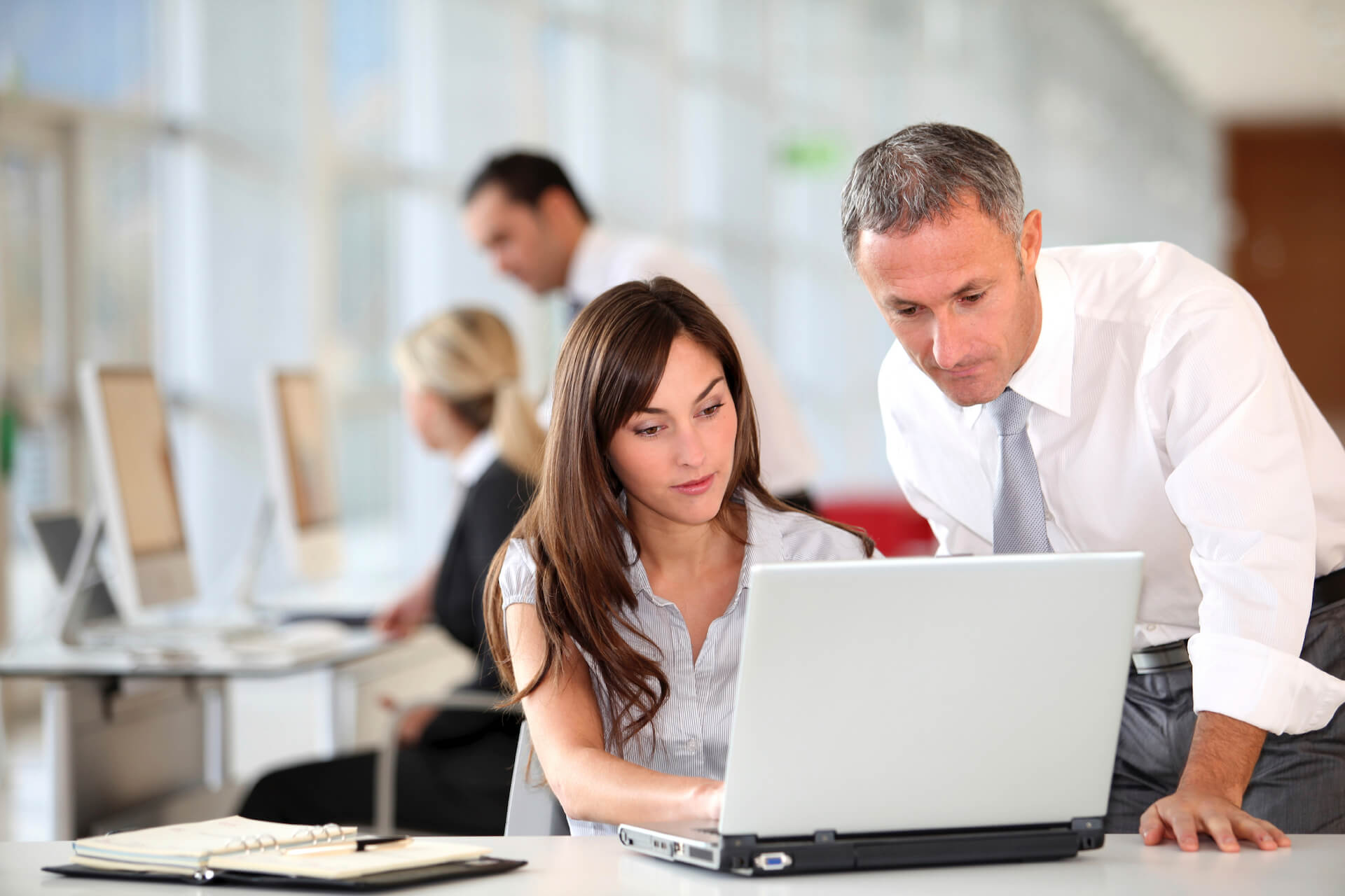 stock image of man supervising lady on laptop